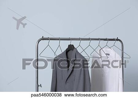 Man's formal and casual outfits hanging on clothes rack, airplane shape in background View Large Photo Image Stock Photo - Man's formal and casual outfits hanging on clothes rack, airplane shape in background. Fotosearch