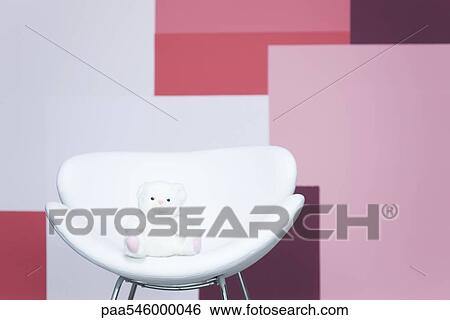 Stock Photograph - Teddy bear sitting on armchair. Fotosearch