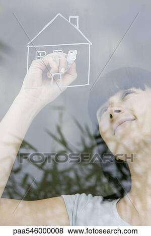 Young woman drawing house on window pane, daydreaming View Large Photo Image Stock Photo - Young woman drawing house on window pane, daydreaming. Fotosearch