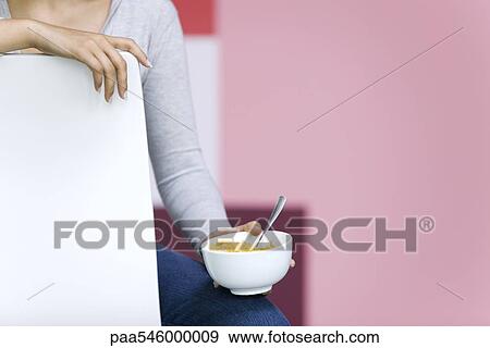 Young woman holding bowl of cornflakes, cropped View Large Photo Image Stock Photo - Young woman holding bowl of cornflakes, cropped. Fotosearch