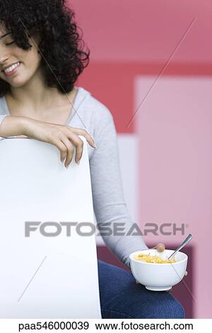 Young woman holding bowl of cornflakes View Large Photo Image Stock Photo - Young woman holding bowl of cornflakes. Fotosearch