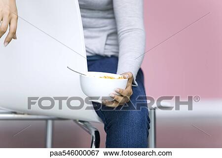 Young woman holding bowl of cornflakes, cropped View Large Photo Image Stock Photo - Young woman holding bowl of cornflakes, cropped. Fotosearch