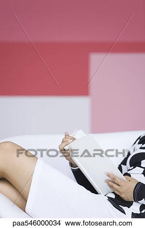 Picture - Young woman relaxing with book. Fotosearch