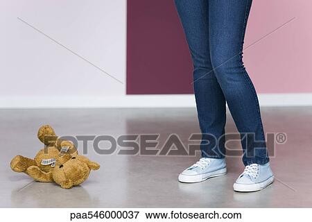 Young woman standing next to teddy bear on floor, low section View Large Photo Image Stock Photo - Young woman standing next to teddy bear on floor, low section. Fotosearch