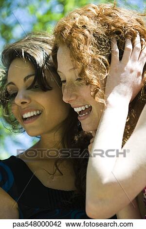 "Two young women cheek to cheek, laughing" View Large Photo Image Stock Image - "Two young women cheek to cheek, laughing". Fotosearch