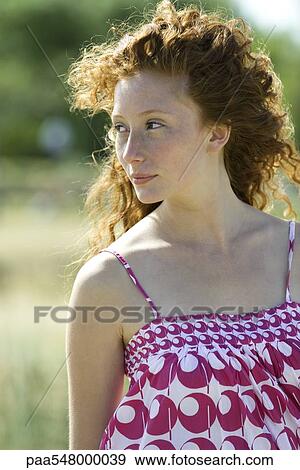 "Young red haired woman outdoors, hair blowing in breeze, portrait" View Large Photo Image Stock Photo - "Young red haired woman outdoors, hair blowing in breeze, portrait". Fotosearch