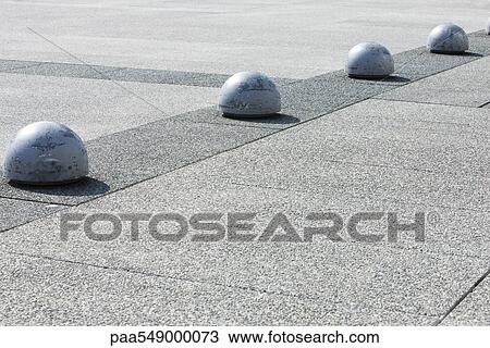 Bollards in line along aggregate concrete pavement View Large Photo Image Stock Image - Bollards in line along aggregate concrete pavement. Fotosearch