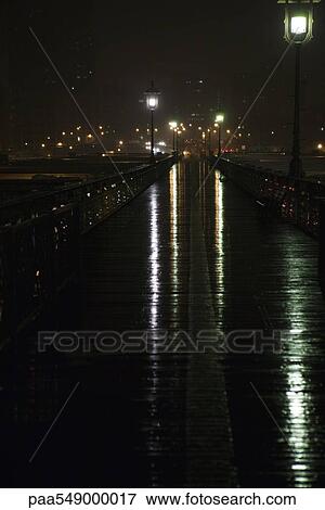 "Elevated pedestrian walkway wet after rain at night, above Brooklyn Bridge, New York City" View Large Photo Image Stock Photo - "Elevated pedestrian walkway wet after rain at night, above Brooklyn Bridge, New York City". Fotosearch