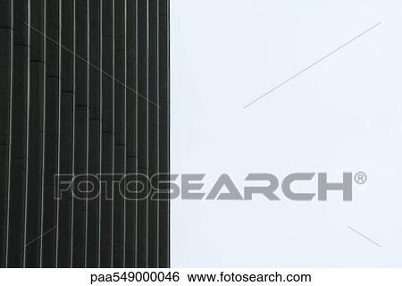Stock Photograph - "Facade of high rise building against sky, cropped". Fotosearch