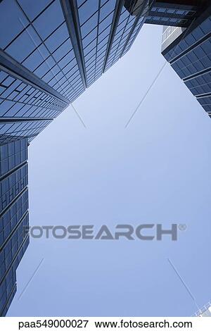 Stock Photo - "High rise office buildings against blue sky, viewed from below, cropped". Fotosearch