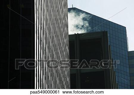 "High rise office buildings side by side, steam vapor billowing from rooftop, low angle view" View Large Photo Image Stock Image - "High rise office buildings side by side, steam vapor billowing from rooftop, low angle view". Fotosearch