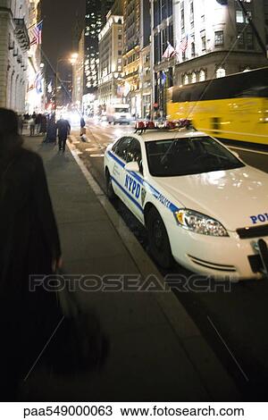 Stock Image - Police car parked on busy street. Fotosearch