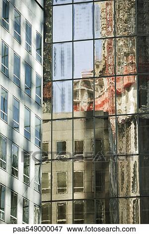 Stock Photo - "Reflection of building on widows of steel and glass high rise office building, cropped". Fotosearch