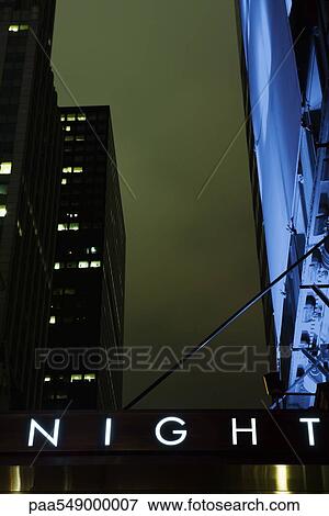 "Sign displaying word ""night"", high rise buildings in background, low angle view" View Large Photo Image Stock Photo - "Sign displaying word ""night"", high rise buildings in background, low angle view". Fotosearch