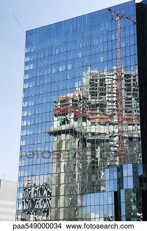 "Steel and glass high skyscraper, reflection of crane above nearby building under construction, cropped" View Large Photo Image Picture - "Steel and glass high skyscraper, reflection of crane above nearby building under construction, cropped". Fotosearch