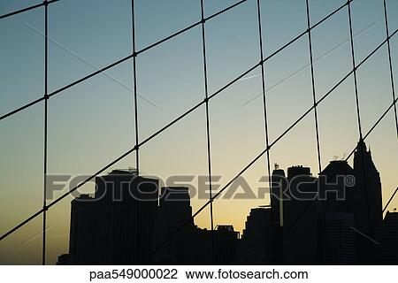 "United States, New York City, silhouette of Manhattan skyline seen through Brooklyn Bridge" View Large Photo Image Stock Image - "United States, New York City, silhouette of Manhattan skyline seen through Brooklyn Bridge". Fotosearch