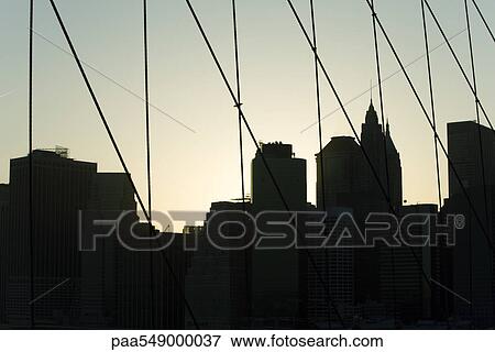 "United States, New York City, silhouette of Manhattan skyline seen through Brooklyn Bridge" View Large Photo Image Stock Photo - "United States, New York City, silhouette of Manhattan skyline seen through Brooklyn Bridge". Fotosearch
