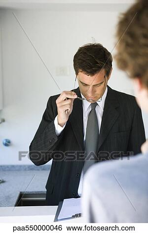 "Businessman reviewing document, associate patiently waiting" View Large Photo Image Stock Photograph - "Businessman reviewing document, associate patiently waiting". Fotosearch