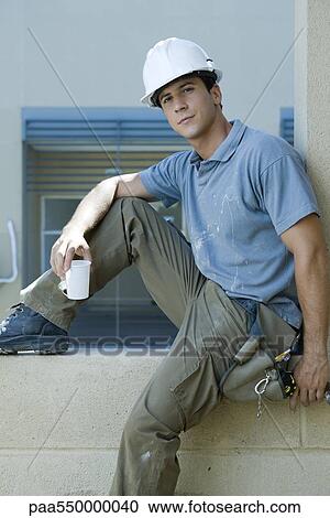 Construction worker siting on window ledge taking break View Large Photo Image Stock Image - Construction worker siting on window ledge taking break. Fotosearch