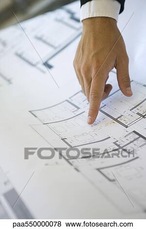 Stock Photo - "Hand pointing at area on blueprint, close-up". Fotosearch