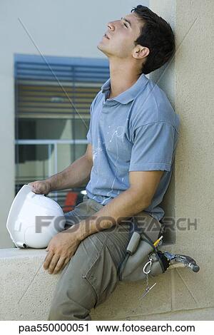 "Man sitting on ledge, leaning head back, looking up" View Large Photo Image Stock Image - "Man sitting on ledge, leaning head back, looking up". Fotosearch