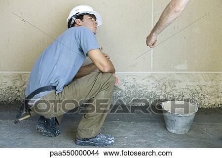 Picture - Mason receiving instructions from supervisor. Fotosearch