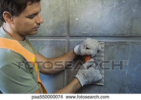"Mason with towel smoothing wall surface, close-up" View Large Photo Image Picture - "Mason with towel smoothing wall surface, close-up". Fotosearch
