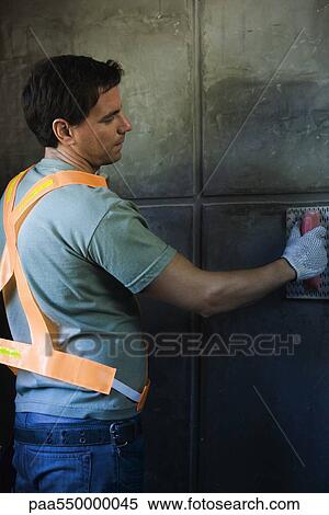 Stock Photography - Mason working with trowel on wall surface. Fotosearch