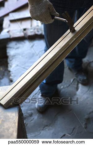Stock Photo - Worker hammering wood. Fotosearch