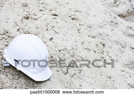 Stock Photo - Hard had set on pile of rubble. Fotosearch