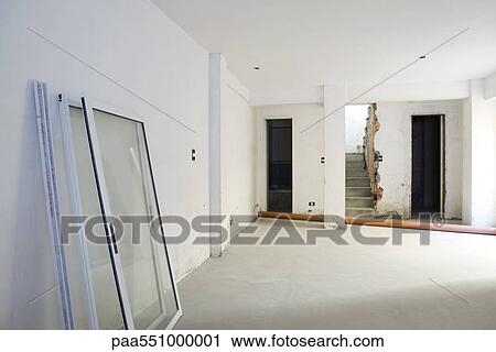 Stock Image - "Interior of apartment under renovation, windows leaning against wall". Fotosearch