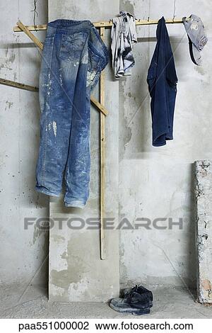 "Jeans, tee-shirt and hat hanging from clothes rack" View Large Photo Image Stock Image - "Jeans, tee-shirt and hat hanging from clothes rack". Fotosearch