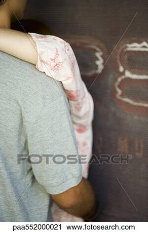 "Couple embracing against wall, cropped" View Large Photo Image Stock Image - "Couple embracing against wall, cropped". Fotosearch