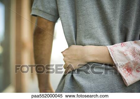 "Woman's arm around man's waist, rear view" View Large Photo Image Stock Photography - "Woman's arm around man's waist, rear view". Fotosearch