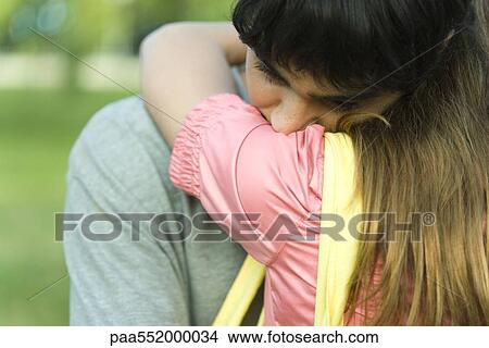 Picture - "Young couple embracing, man's head on woman's shoulder, close-up". Fotosearch