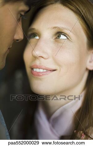 Stock Photo - "Young couple gazing into each other's eyes, smiling, close-up". Fotosearch