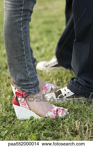 "Young couple in trendy clothing standing face to face, low section" View Large Photo Image Picture - "Young couple in trendy clothing standing face to face, low section". Fotosearch