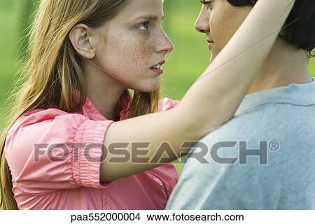 "Young couple staring into each other's eyes, side view" View Large Photo Image Picture - "Young couple staring into each other's eyes, side view". Fotosearch