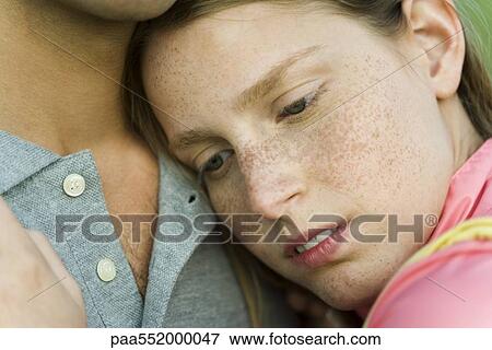 Stock Photo - "Young woman resting head on man's chest, close-up". Fotosearch