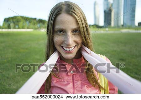 "Young woman wearing scarf, smiling at camera" View Large Photo Image Picture - "Young woman wearing scarf, smiling at camera". Fotosearch