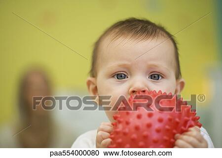 Baby holding toy in front of mouth View Large Photo Image Stock Image - Baby holding toy in front of mouth. Fotosearch