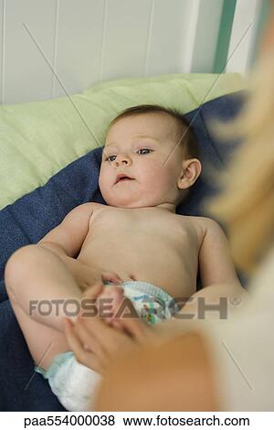Baby lying in crib, mother holding baby's foot, cropped view View Large Photo Image Stock Photo - Baby lying in crib, mother holding baby's foot, cropped view. Fotosearch