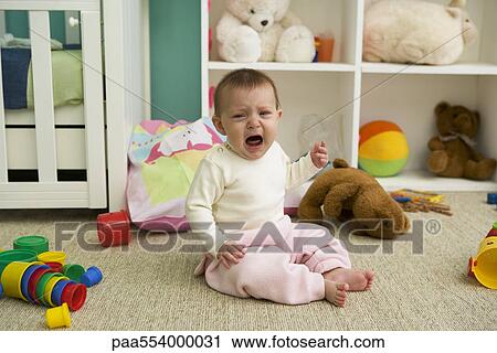 Baby sitting on floor of nursery, crying View Large Photo Image Stock Image - Baby sitting on floor of nursery, crying. Fotosearch