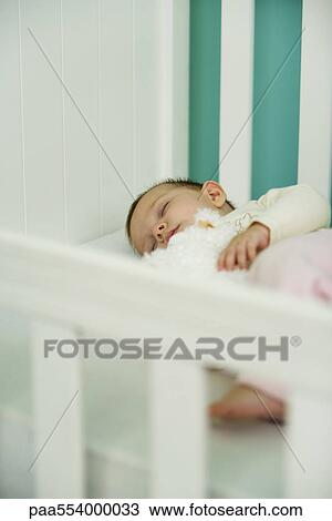 Stock Image - Baby sleeping in crib. Fotosearch