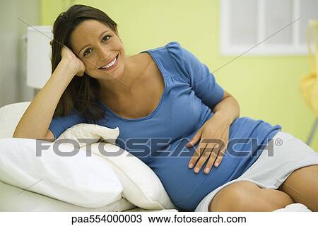 Pregnant woman relaxing, smiling at camera, portrait View Large Photo Image Stock Image - Pregnant woman relaxing, smiling at camera, portrait. Fotosearch