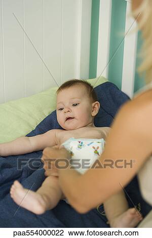 Woman changing baby's diaper View Large Photo Image Stock Image - Woman changing baby's diaper. Fotosearch
