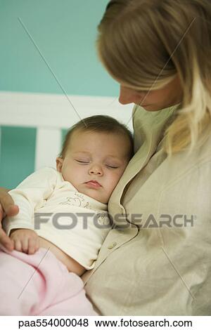 Stock Photo - Young mother holding sleeping baby. Fotosearch