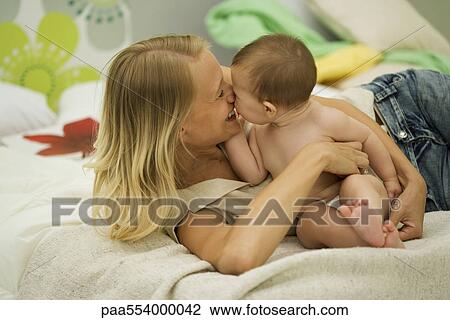 Stock Image - Young mother nuzzling baby. Fotosearch
