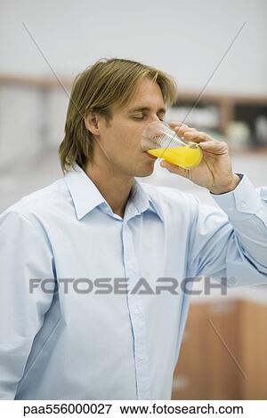 Man drinking orange juice View Large Photo Image Stock Photo - Man drinking orange juice. Fotosearch