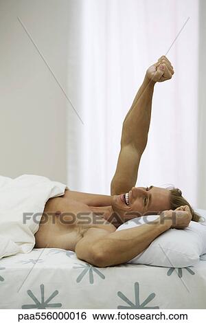 Man in bed waking up, stretching View Large Photo Image Stock Photograph - Man in bed waking up, stretching. Fotosearch